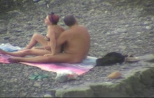 An old guy groping his wife on a public beach